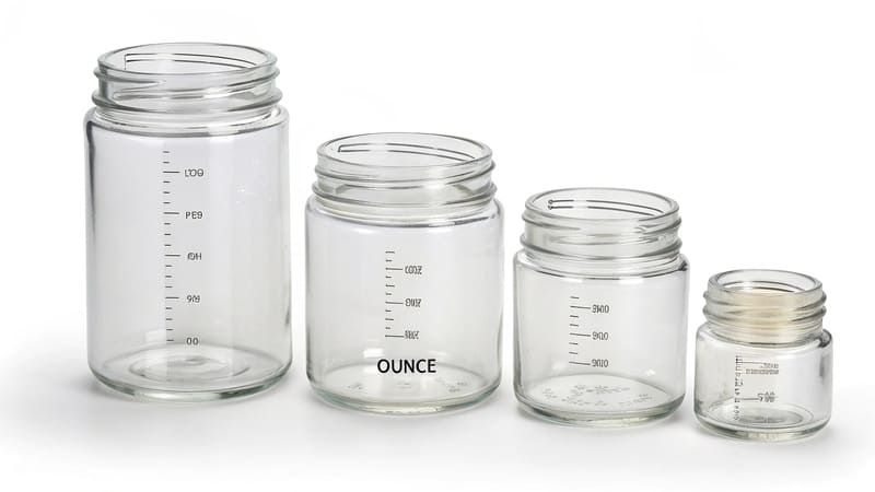 various sizes of glass cosmetic jars with ounce markings