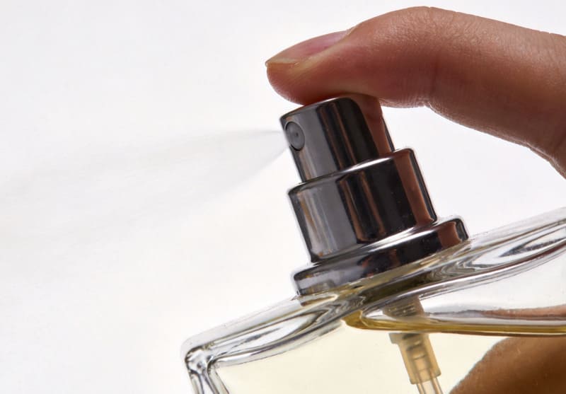 Fixing an airlock in a perfume bottle A perfume bottle being held upside down, with a finger pressing the pump.